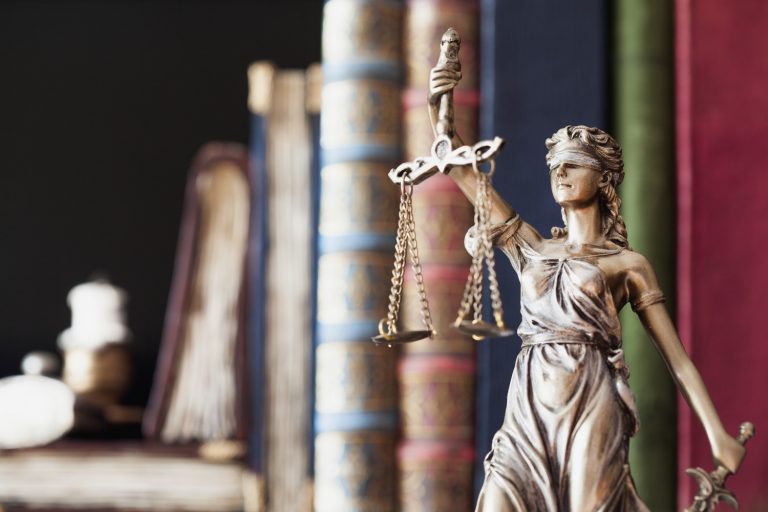 Statue of Justice in front of law books